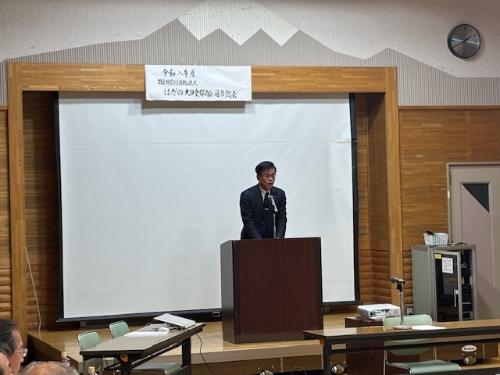 演題の後ろに立って挨拶する市長、その背後は床までスクリーンがある。