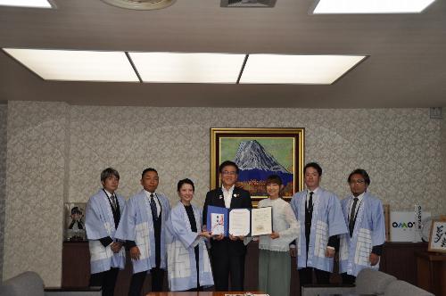 はっぴを着た秦野祭囃し社中の5名の皆さんと石黒彩さんと市長の写真