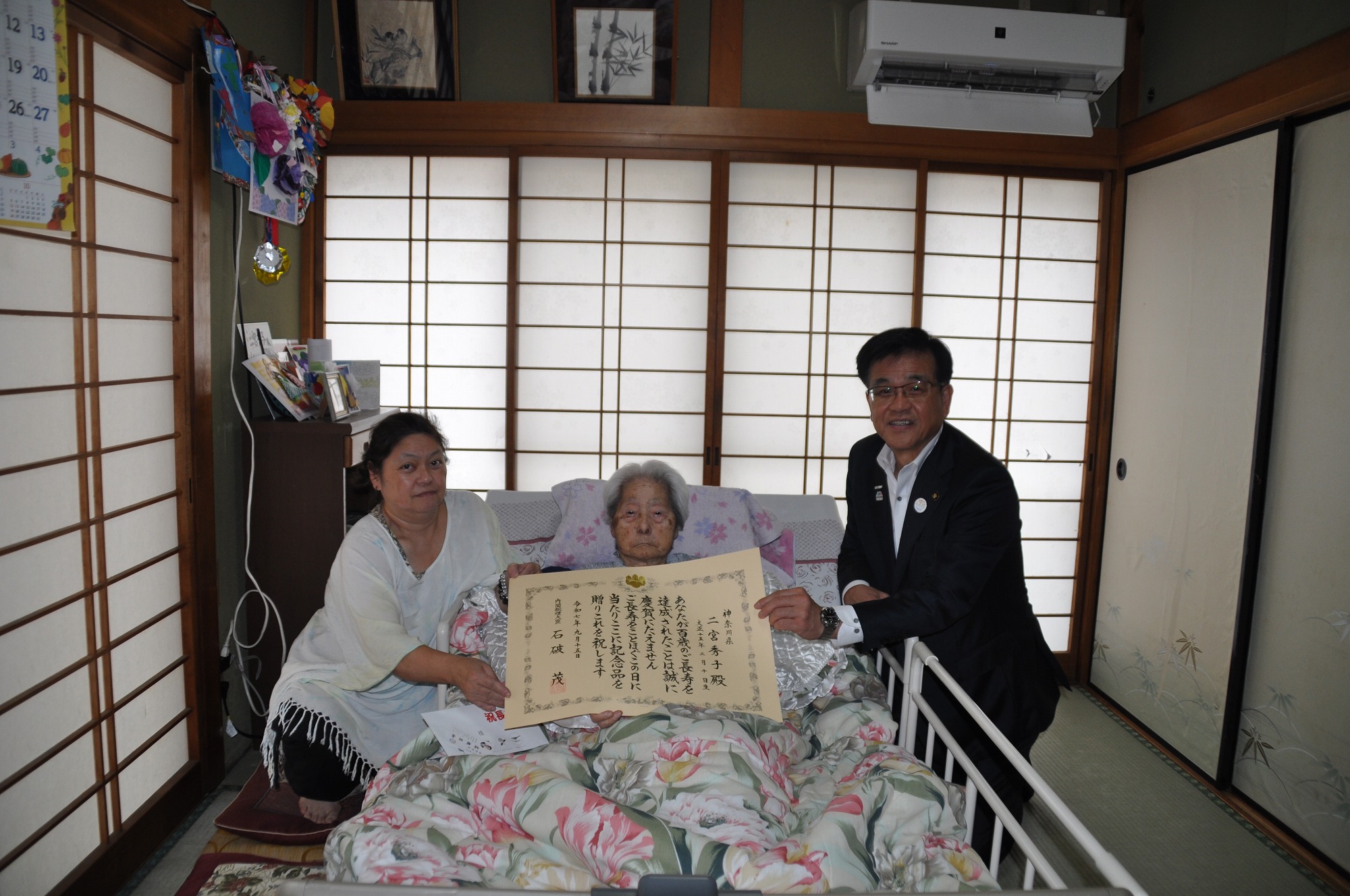 100歳を迎えた方とそのご家族と市長の記念写真