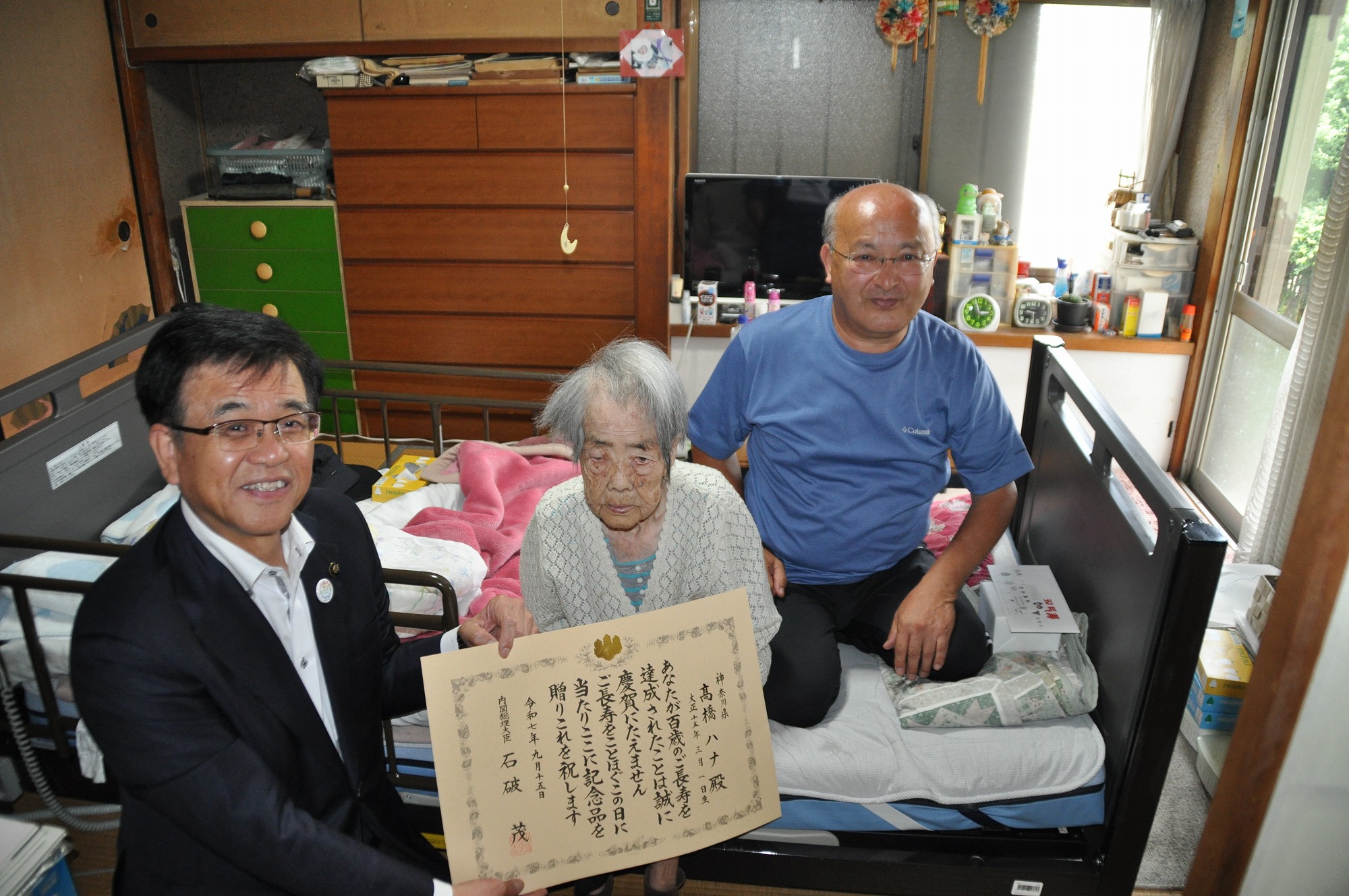 100歳を迎えた女性とそのご家族と市長の記念写真