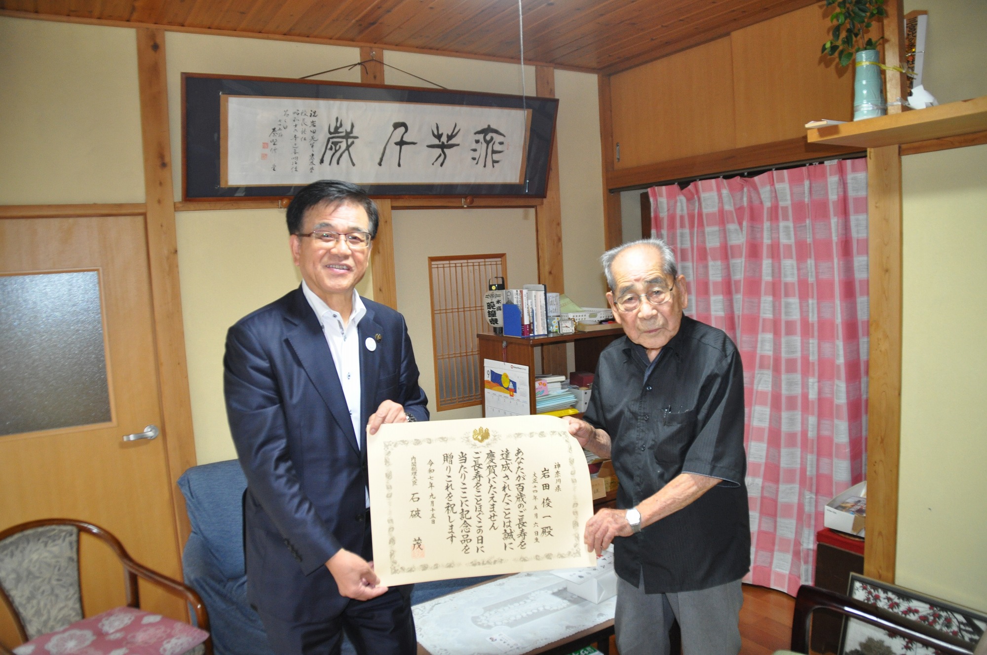 100歳を迎えた男性と市長の記念写真