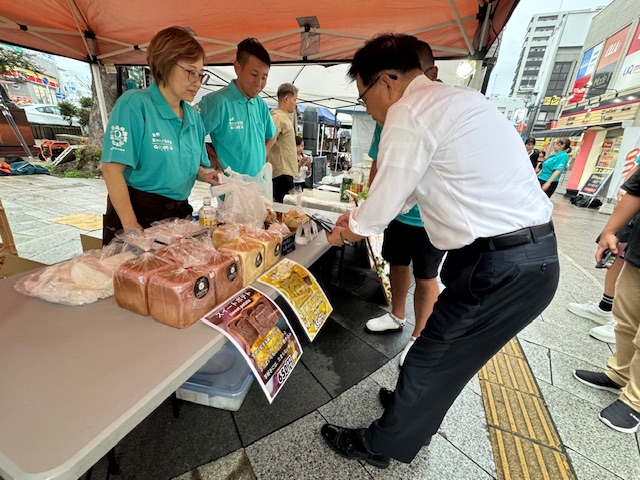 秦野駅北口で開催されたマルシェで買い物をする市長