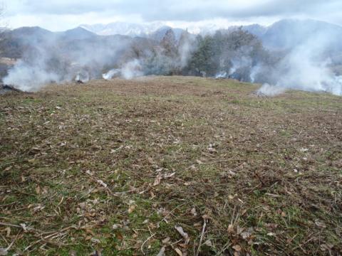 草が広がる農地に、数か所から白い煙が上がっている野焼きの風景写真