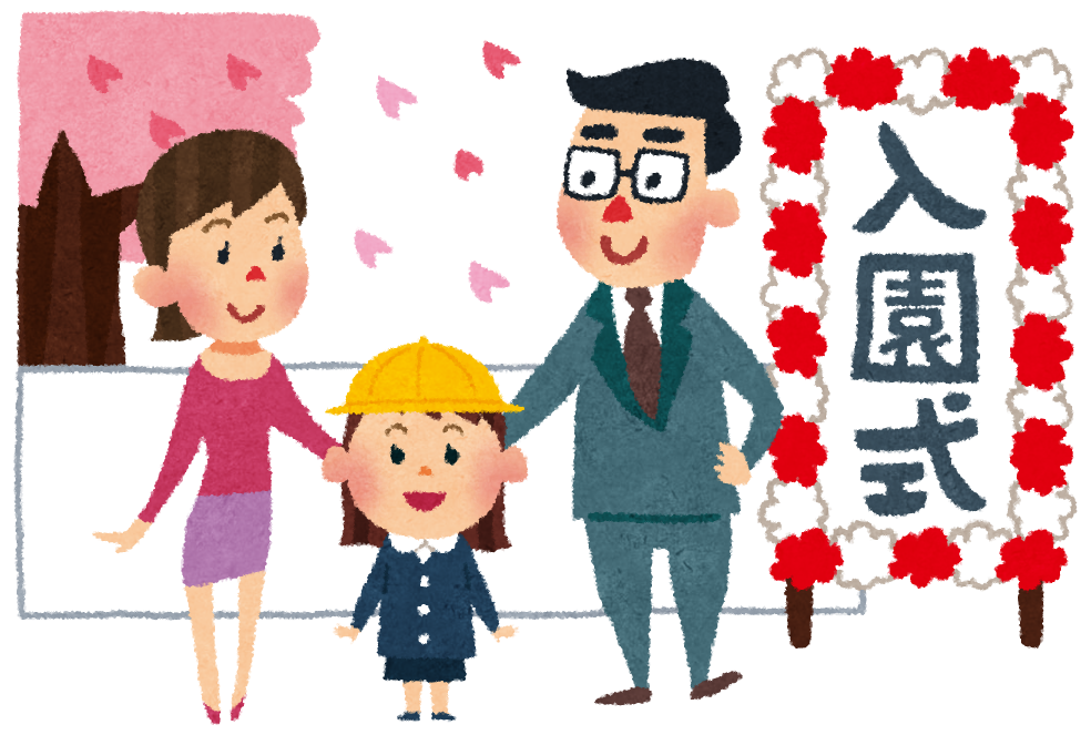 桜が舞い散る中、入園式と書かれた看板の隣で、黄色い帽子を被った園児が両親と一緒に笑顔で立っている写真