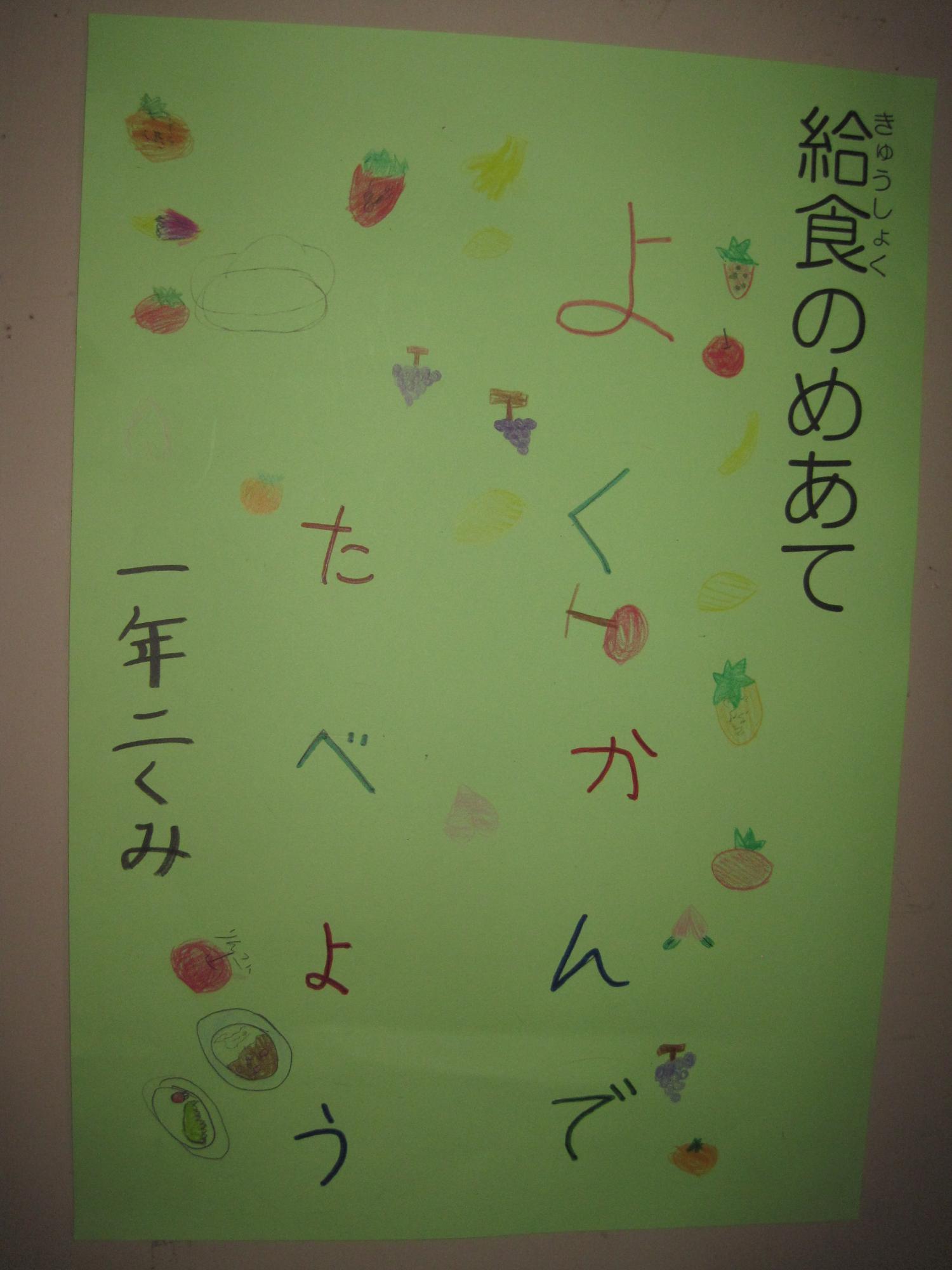 「給食のめあて」「よくかんでたべよう」「一年二くみ」と手書きされた学校の掲示物の写真
