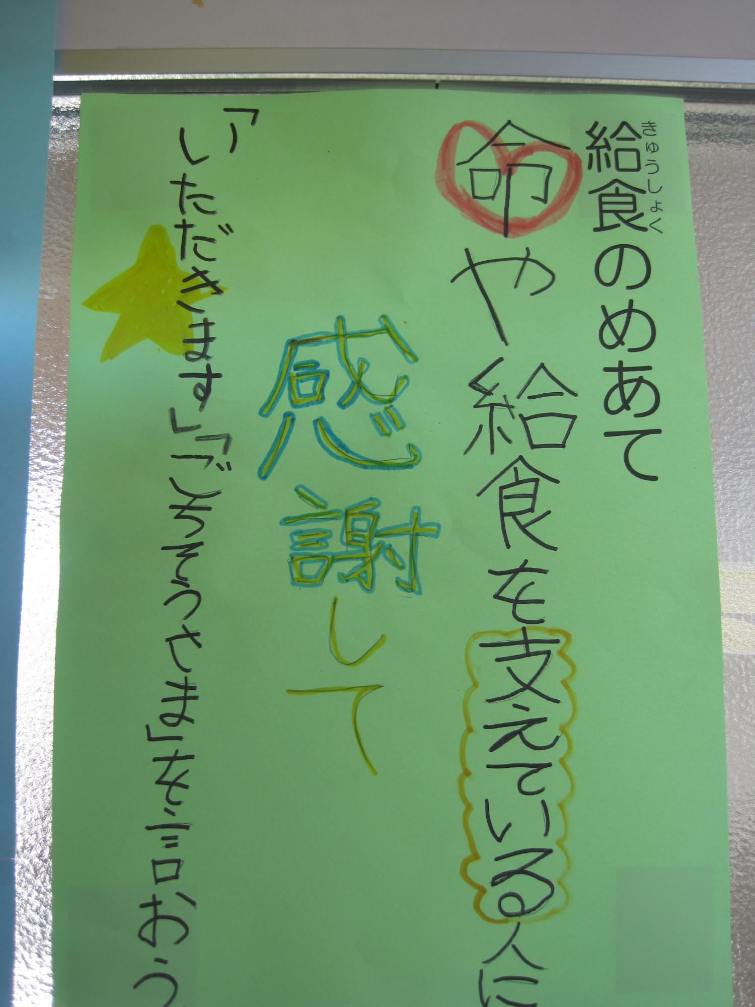 「給食のめあて」と縦書きし、「命や給食を支えている人に感謝して「いただきます」「ごちそうさま」を言おう」が手書きされた学校の掲示物の写真