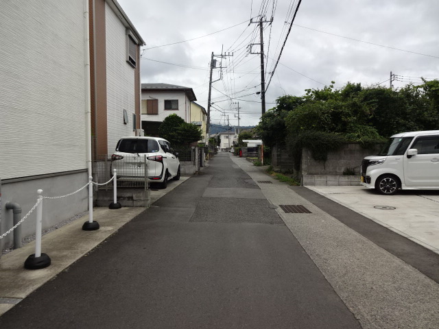 住宅街で、道幅の狭い細長い道路が長く続いている写真