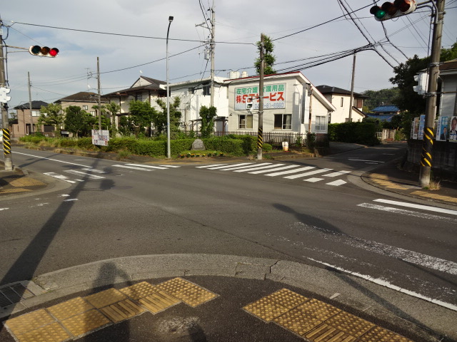 交差点で、手前右下の点字ブロックと色が薄くラインが消えかかった横断歩道の写真