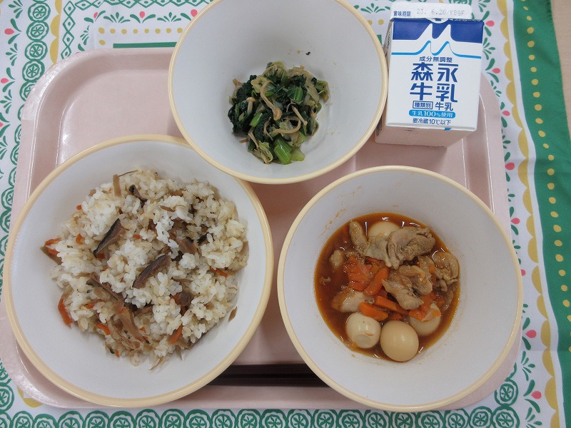 ピンクのトレーに給食が右上から反時計回りで牛乳、磯香和えかやくごはん、鶏肉とうずら卵のスパイシー炒めと並べられている写真