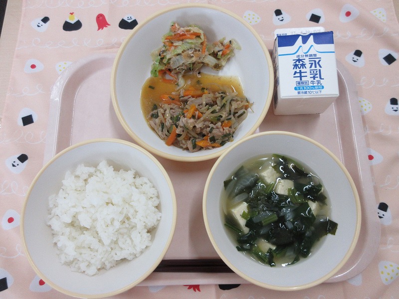 ピンクのトレーに給食が右上から反時計回りで牛乳、プルコギとチョレギ風サラダ、ごはん、豆腐スープと並べられている写真