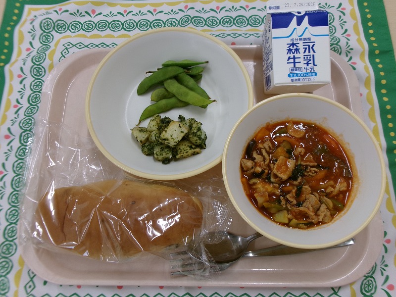 ピンクのトレーに給食が右上から反時計回りで牛乳、枝豆と青のりポテト、ぶどうパン、ラタトゥイユと並べられている写真