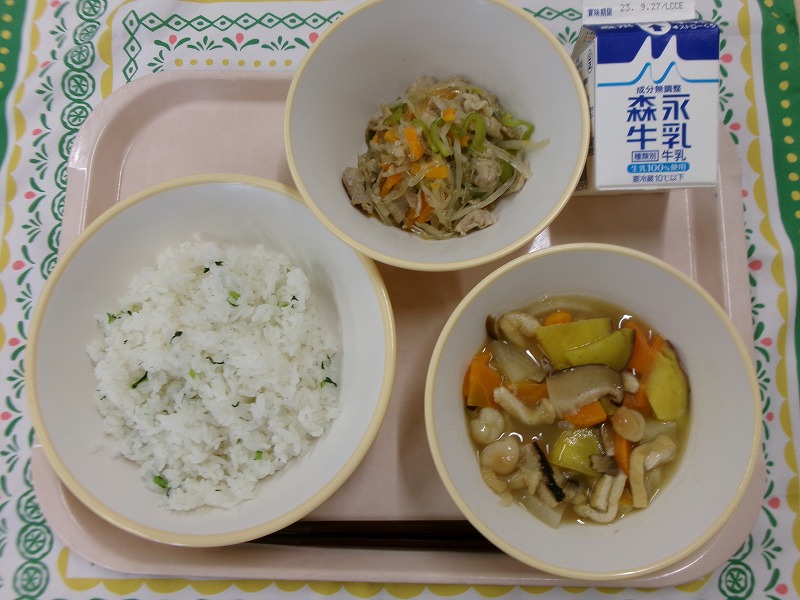 ピンクのトレーに給食が右上から反時計回りで牛乳、春雨の五目炒め、菜めし、おくずかけと並んでいる写真