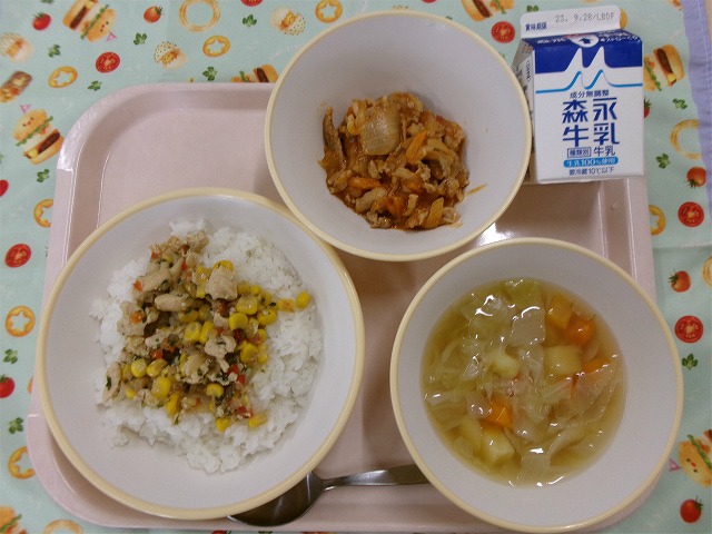 ピンクのトレーに給食が右上から反時計回りで牛乳、ポークチャップ、ガリバタチキンライス、野菜スープと並んでいる写真