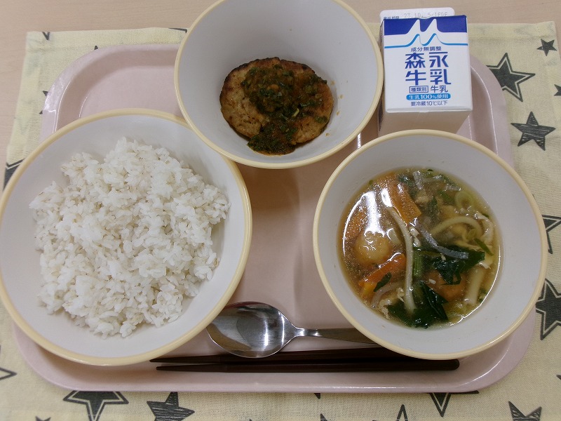 ピンクのトレーに給食が右上から反時計回りで牛乳、和風ハンバーグ、ご飯、あんかけ汁と並んでいる写真