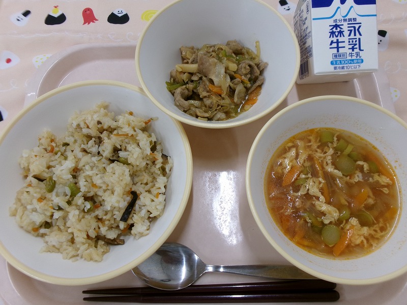 ピンクのトレーに給食が右上から反時計回りで牛乳、チンジャオロース、中華風おこわ、鎮江香酢で本格的！彩りたまごスープと並んでいる写真