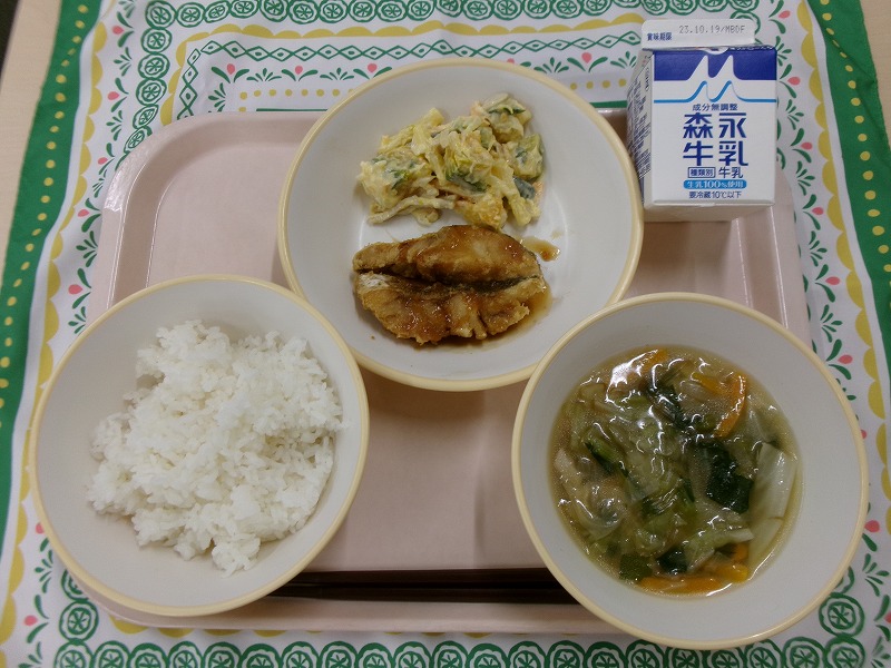 ピンクのトレーに給食が右上から反時計回りで牛乳、白身魚の香味ソースがけとかぼちゃのマヨサラダ、ご飯、春雨スープと並んでいる写真