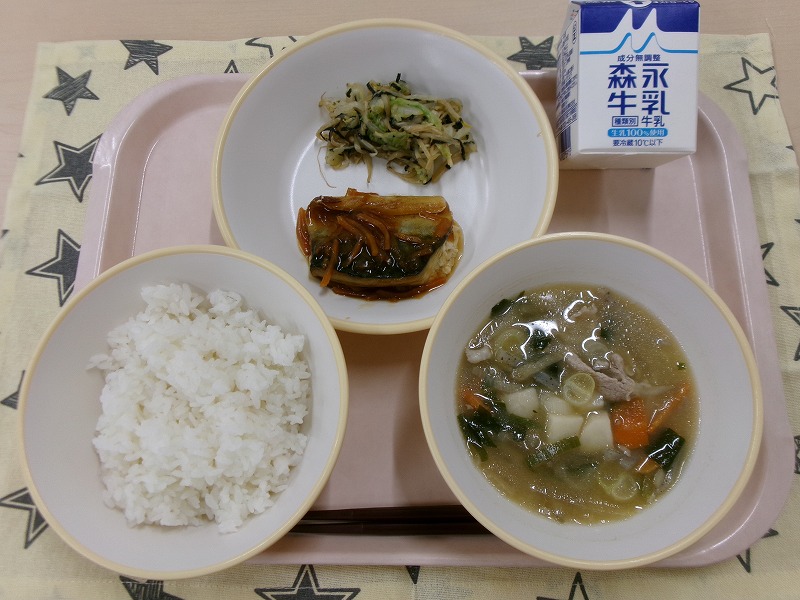 ピンクのトレーに給食が右上から反時計回りで牛乳、さばの甘酢あんかけと磯香和え、ご飯、豚汁と並んでいる写真