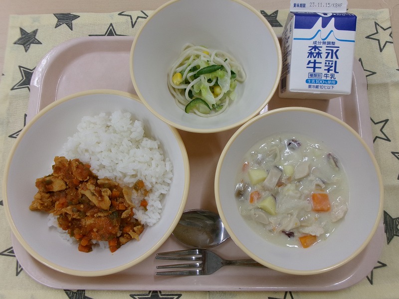 ピンクのトレーに給食が右上から反時計回りで牛乳、ミックスサラダ、チキンライス、秋の味覚シチューと並んでいる写真