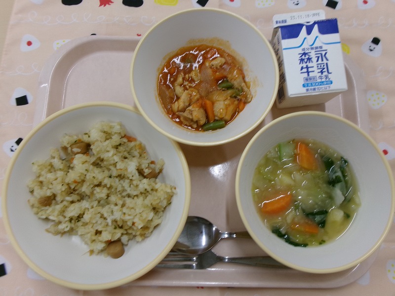 ピンクのトレーに給食が右上から反時計回りで牛乳、鶏肉のケチャップ炒め、ウインナー入りピラフ、野菜のスープ煮と並んでいる写真