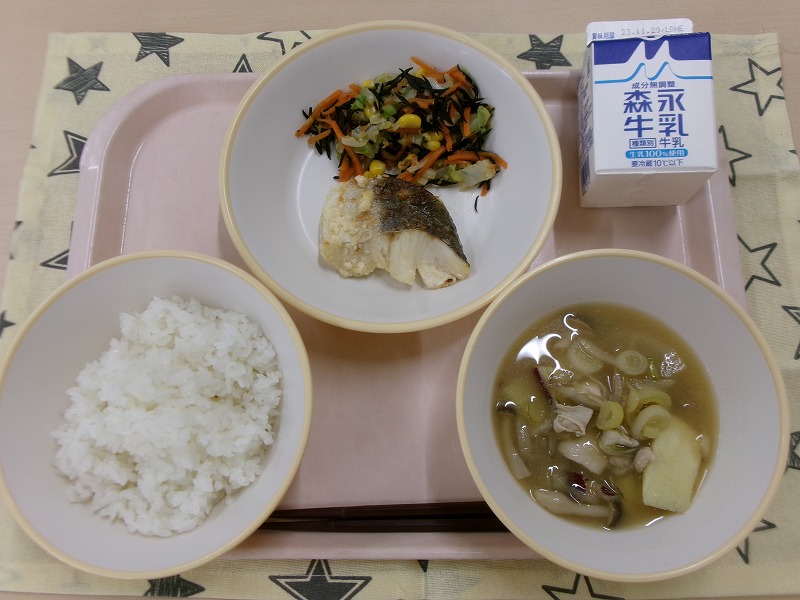 ピンクのトレーに給食が右上から反時計回りで牛乳、白身魚のマヨネーズ焼きとひじきサラダ、ご飯、さつま汁と並んでいる写真