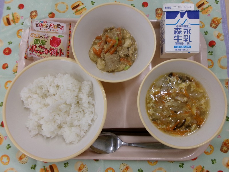 ピンクのトレーに給食が右上から反時計回りで牛乳、肉豆腐あんかけ、りんごタルト、ご飯、中華風たまごスープと並んでいる写真