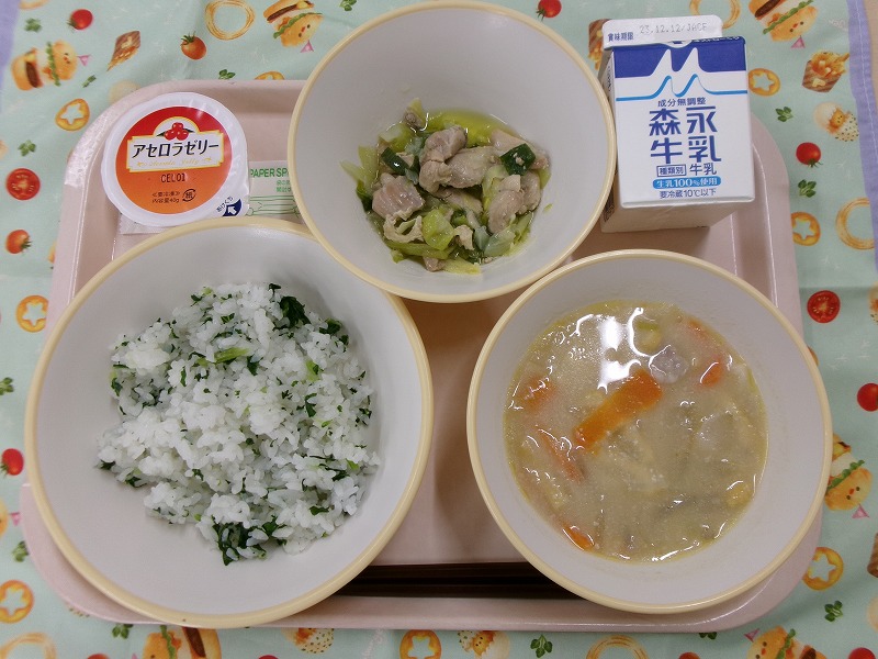 ピンクのトレーに給食が右上から反時計回りで牛乳、鶏肉とキャベツのねぎ塩炒め、アセロラゼリー、菜めし、粕汁と並んでいる写真