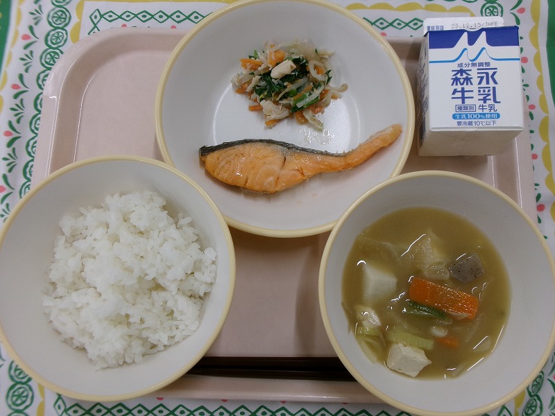 ピンクのトレーに給食が右上から反時計回りで牛乳、鮭の塩焼きとささみ入りナムル、ご飯、みそけんちん汁と並んでいる写真