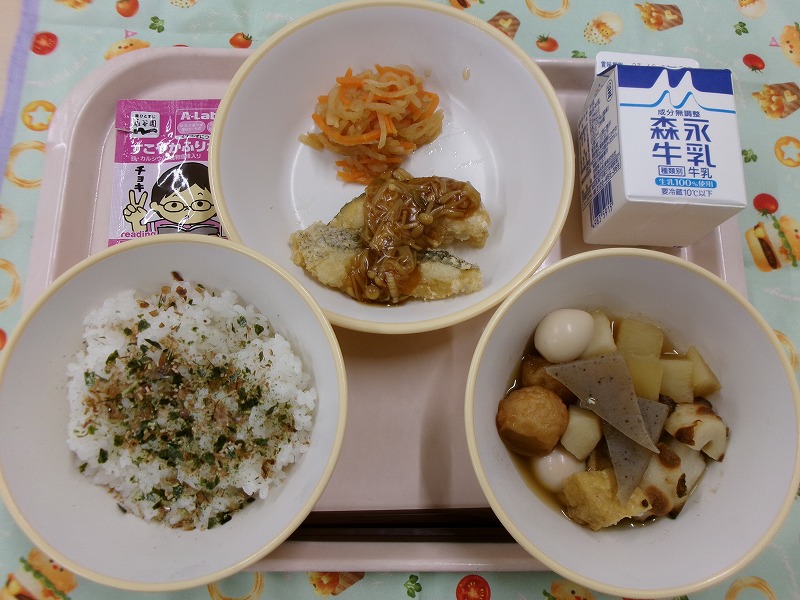 ピンクのトレーに給食が右上から反時計回りで牛乳、白身魚の和風あんかけとゆずドレ大根サラダ、ごはん（おかかふりかけ）、おでんと並んでいる写真