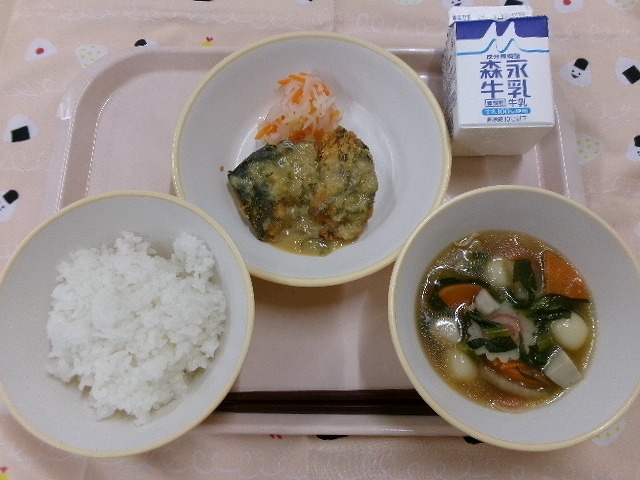 ピンクのトレーに給食が右上から反時計回りで牛乳、さわらのみそだれと紅白なます、ご飯、白玉雑煮と並んでいる写真