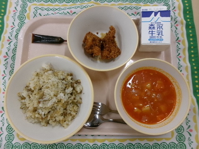 ピンクのトレーに給食が右上から反時計回りで牛乳、チキンカツ、ミルメーク、ごぼうピラフ、ミネストローネと並んでいる写真