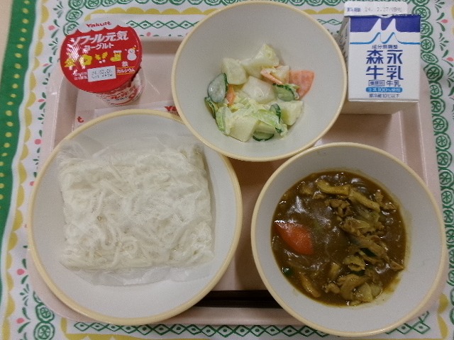 ピンクのトレーに給食が右上から反時計回りで牛乳、ポテトサラダ、ヨーグルト、ソフト麺、カレーあんかけと並んでいる写真