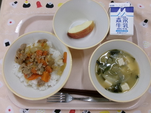 ピンクのトレーに給食が右上から反時計回りで牛乳、りんご、豚丼、豆腐の味噌汁と並んでいる写真