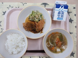 ピンクのトレーに給食が右上から反時計回りで牛乳、油淋鶏とささみとキャベツの昆布和え、ご飯、あんかけ汁 と並んでいる写真