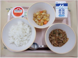 ピンクのトレーに給食が右上から反時計回りで牛乳、じゃがいものソテー、アセロラゼリー、ご飯、ホイコーローと並んでいる写真
