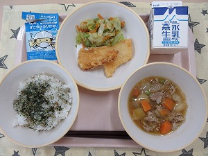 ピンクのトレーに給食が右上から反時計回りで牛乳、いかの吉野揚げとごま和え 、わかめふりかけ入りご飯、肉じゃがと並んでいる写真