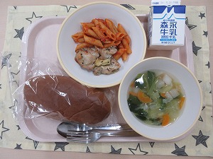 ピンクのトレーに給食が右上から反時計回りで牛乳、鶏肉のハーブ焼きとペンネアラビアータ、黒パン、野菜スープと並んでいる写真