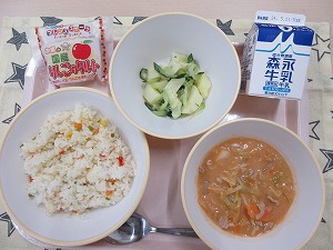 ピンクのトレーに給食が右上から反時計回りで牛乳、ポテトサラダ、りんごタルト、カラフルピラフ、豚肉とキャベツのトマトクリーム煮と並んでいる写真