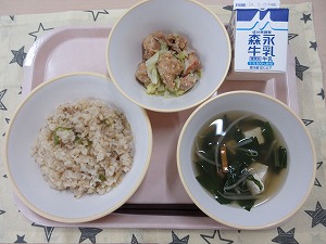 ピンクのトレーに給食が右上から反時計回りで牛乳、鶏肉とキャベツの旨塩炒め、チャーハン風まぜごはん、豆腐の中華スープと並んでいる写真