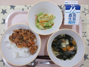 ピンクのトレーに給食が右上から反時計回りで牛乳、しらたきサラダ、豚キムチ丼、わかめスープと並んでいる写真