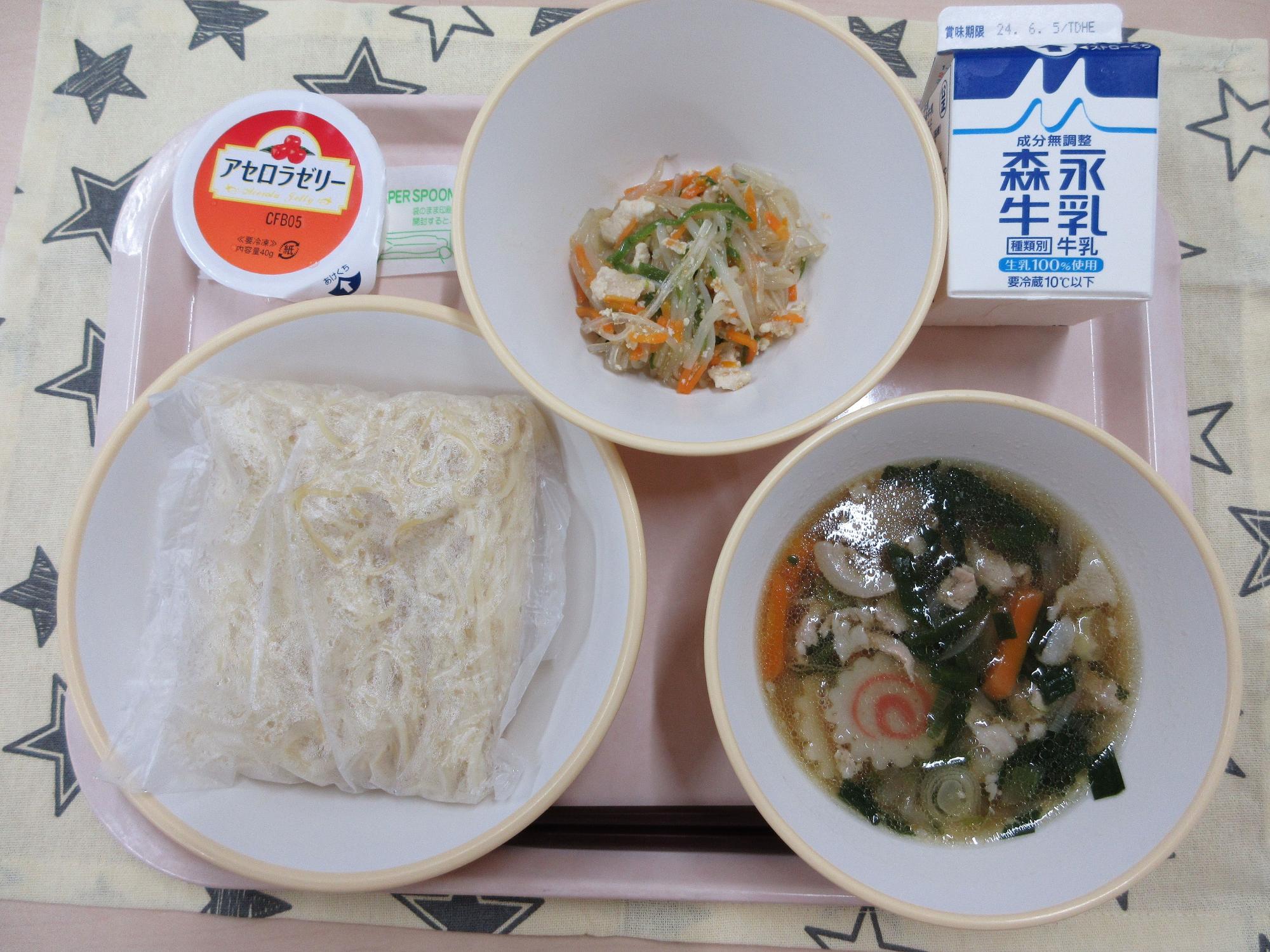 ピンクのトレーに給食が右上から反時計回りで牛乳、春雨の中華炒め 、アセロラゼリー、しょうゆラーメンと並んでいる写真