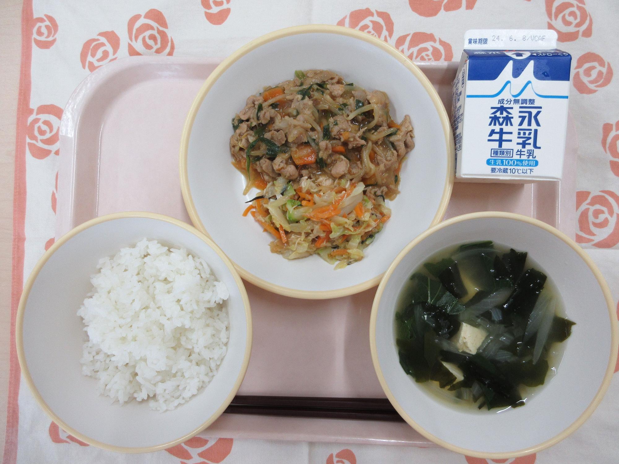 ピンクのトレーに給食が右上から反時計回りで牛乳、プルコギ とチョレギサラダ、ご飯、豆腐スープと並んでいる写真