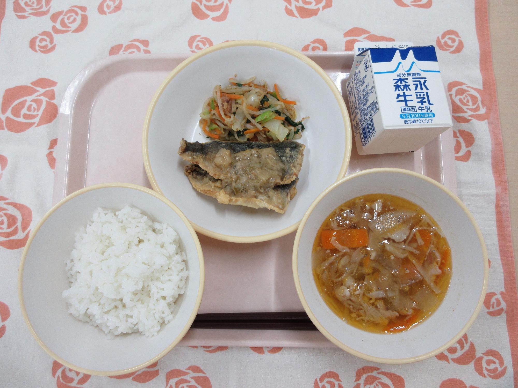 ピンクのトレーに給食が右上から反時計回りで牛乳、あじの梅みそだれと野菜のおかか和え、ご飯、切り干し大根のピリ辛スープと並んでいる写真