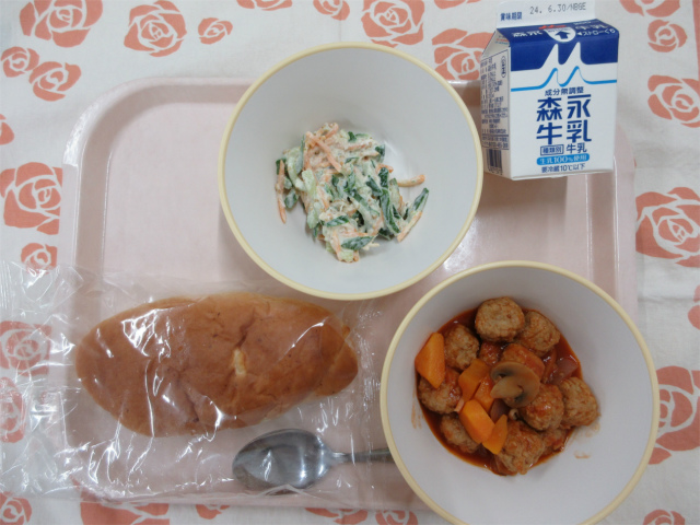 ピンクのトレーに給食が右上から反時計回りで牛乳、きゅうりのごまマヨサラダ、チーズパン、ミートボールのトマト煮と並んでいる写真