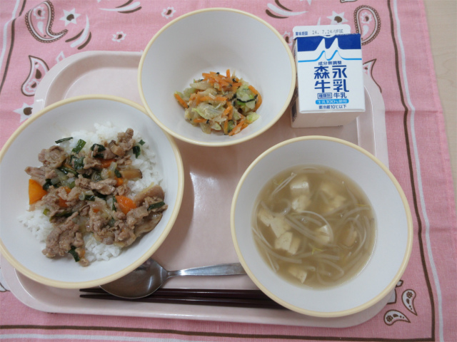 ピンクのトレーに給食が右上から反時計回りで牛乳、チョレギサラダ、焼肉丼、ビーフンスープと並んでいる写真