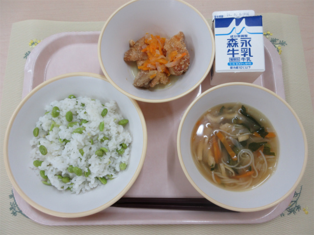 ピンクのトレーに給食が右上から反時計回りで牛乳、鶏肉の南蛮漬け 、枝豆おこわ、そうめん汁と並べられている写真