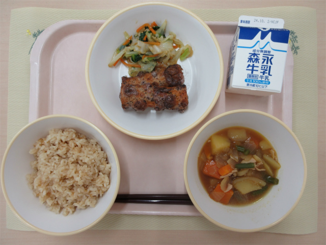 ピンクのトレーに給食が右上から反時計回りで牛乳、ごま和え、ちくわのゆかり揚げ、茶飯、野菜の旨煮と並べられている写真