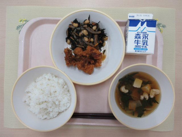 ピンクのトレーに給食が右上から反時計回りで牛乳、ひじきの炒り煮、チキンカツ、ごはん、すまし汁と並べられている写真