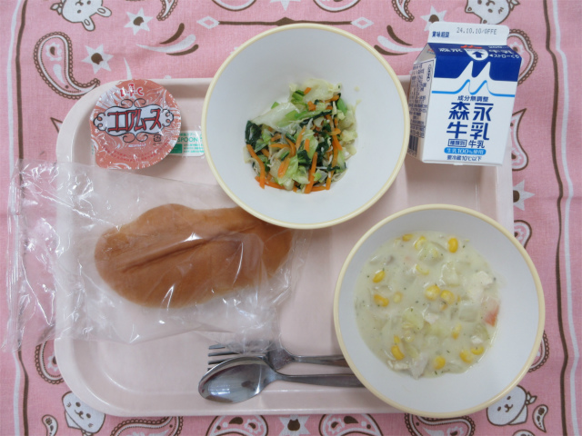 ピンクのトレーに給食が右上から反時計回りで牛乳、じゃこサラダ、ココアムース、ソフトフランスパン、コーンシチューと並べられている写真