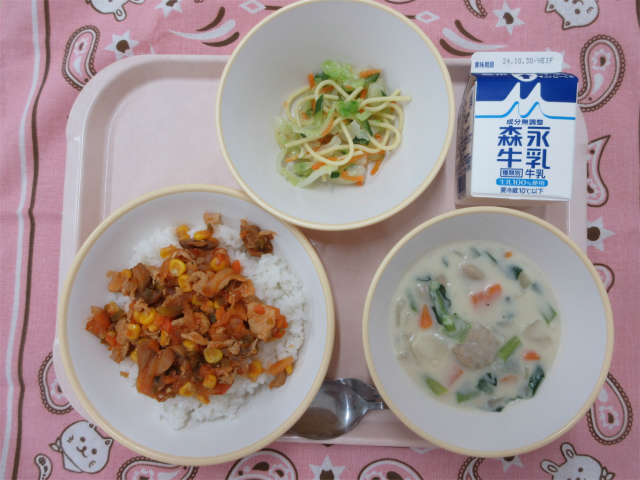 ピンクのトレーに給食が右上から反時計回りで牛乳、ミックスサラダ、チキンライス（ごはん）、ミートボールのクリームシチューと並べられている写真