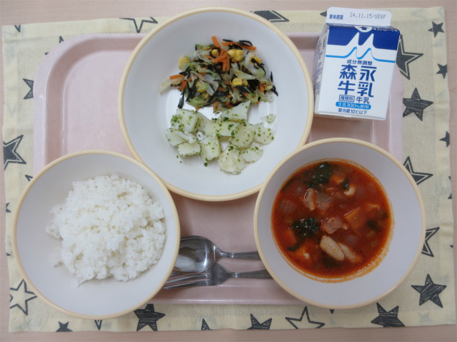 ピンクのトレーに給食が右上から反時計回りで牛乳、ひじきのサラダ、粉ふきいも、ごはん、鶏肉のトマト煮と並べられている写真